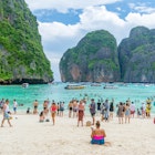 MAYA BAY, THAILAND - June 21, 2017: Crowds of sunbathing visitors enjoy a day trip boat ride to Maya Bay, one of the iconic beaches of Southern Thailand.